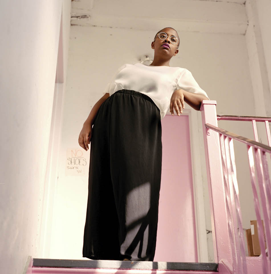 Cécile McLorin Salvant on a staircase wearing a white blouse and long black skirt