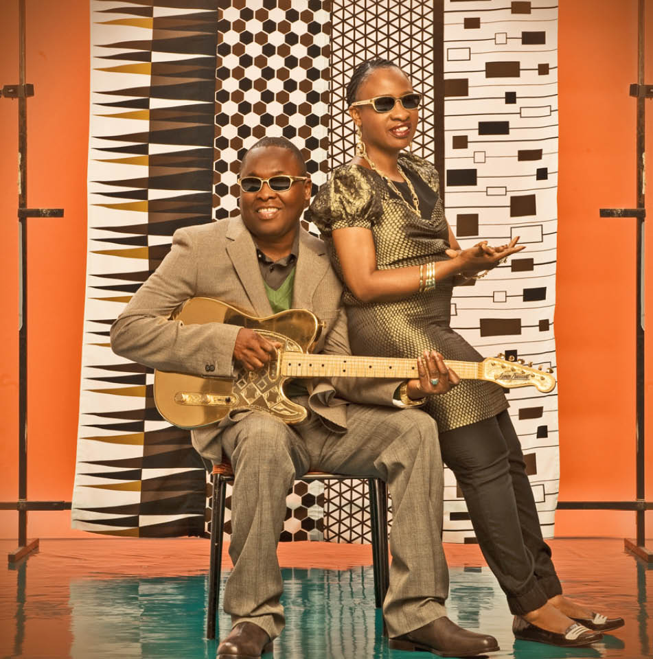 Amadou & Mariam in gold-themed clothing against a vibrant background