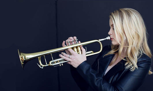 Bria Skonberg blowing on the trumpet
